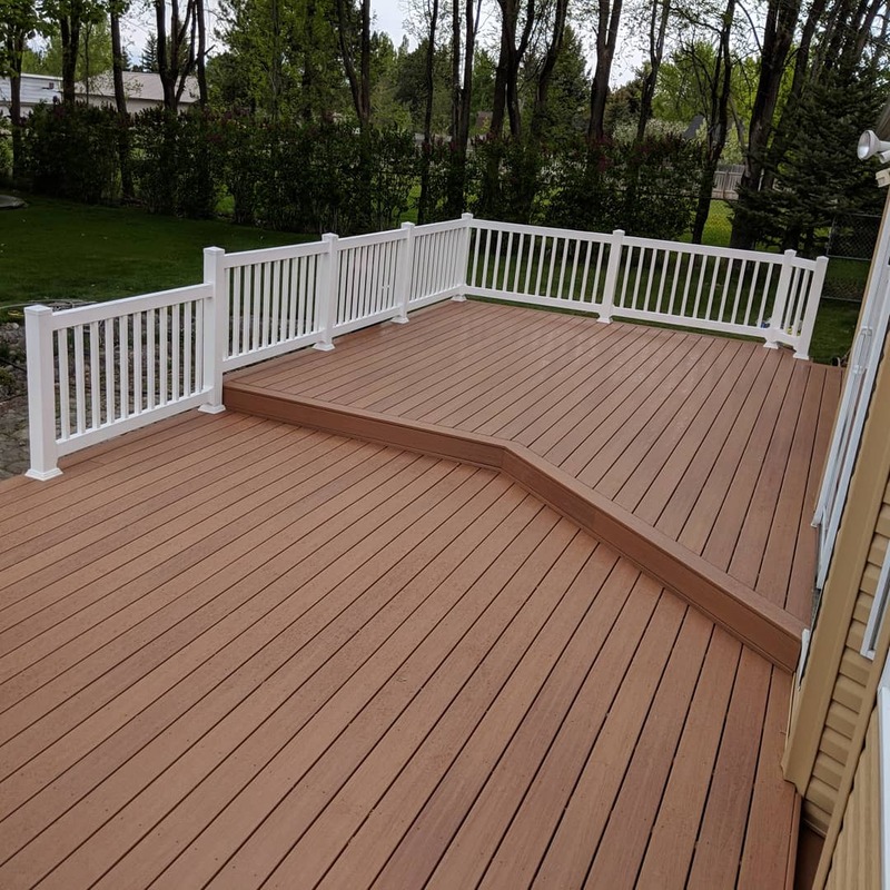 Upgrade your backyard with a custom multi-level composite deck from DeckPro LLC. This project features durable brown composite decking paired with clean white vinyl railing, creating a beautiful, low-maintenance outdoor living space with distinct zones for relaxing and entertaining.