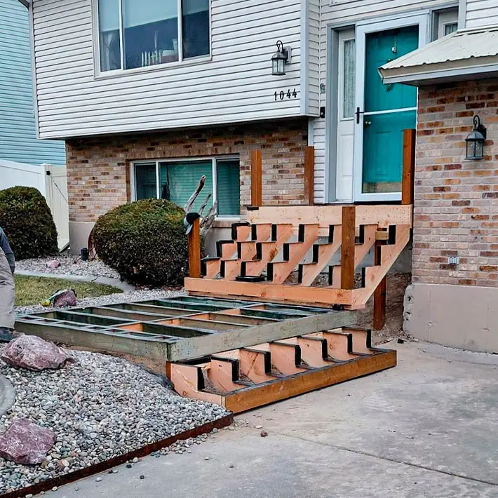 New wood deck construction in progress, featuring the precision-cut pressure-treated stringers for the new entry stairs.