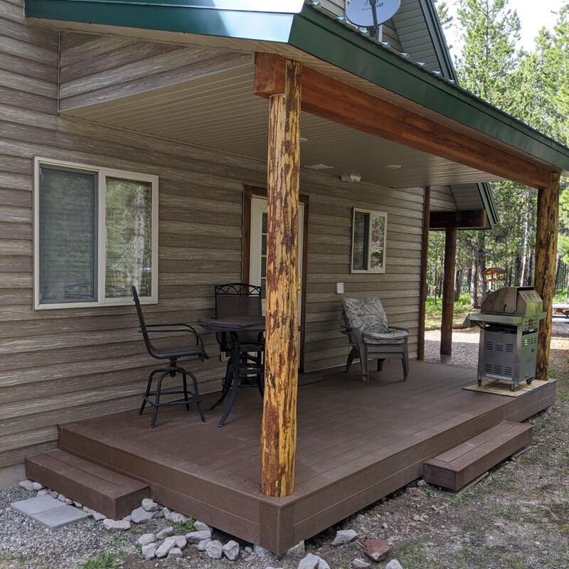 Extend your multi-level outdoor living with this rustic custom composite deck transformation by DeckPro LLC. We took a classic mountain log cabin home with rough grading and rough landscaping, pictured bordering natural vegetation and a dirt road construction area, and turned it into a sturdy and sophisticated functional retreat.
