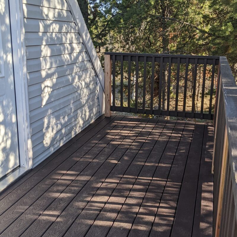 Extend your outdoor living possibilities with this custom deck by DeckPro LLC, which combines rustic elements with modern materials. We installed low-maintenance composite decking in a warm brown tone and paired it with a unique railing system that features natural wood posts and integrated wire mesh infill panels. For the ultimate in functional design, we included extensive built-in L-shaped bench seating, creating a cozy and inviting perimeter perfect for taking in scenic views.