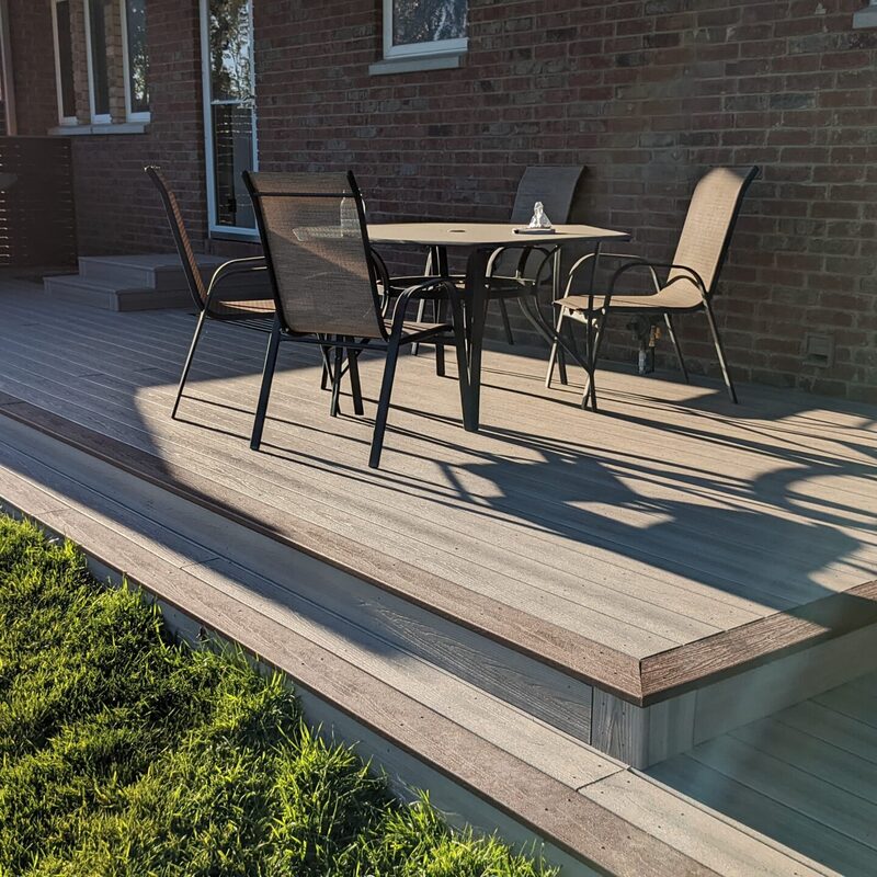 Extend your outdoor living possibilities with this custom deck by DeckPro LLC, which combines rustic elements with modern materials. We installed low-maintenance composite decking in a warm brown tone and paired it with a unique railing system that features natural wood posts and integrated wire mesh infill panels. This functional design creates a cozy perimeter, perfect for relaxing and taking in scenic views.