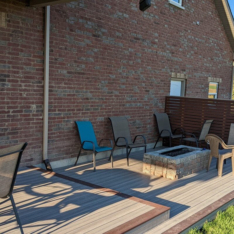 Extend your outdoor living possibilities with this custom deck by DeckPro LLC, which combines rustic elements with modern materials. We installed low-maintenance composite decking in a warm brown tone and paired it with a unique railing system that features natural wood posts and integrated wire mesh infill panels. For the ultimate in functional design, we included extensive built-in L-shaped bench seating, creating a cozy and inviting perimeter perfect for taking in scenic views.