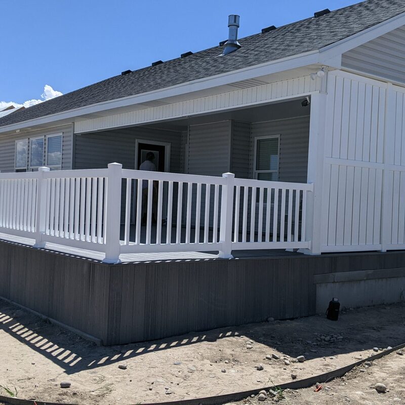 Extend your outdoor living possibilities with this custom deck by DeckPro LLC, which combines rustic elements with modern materials. We installed low-maintenance composite decking in a warm brown tone and paired it with a unique railing system that features natural wood posts and integrated wire mesh infill panels. For the ultimate in functional design, we included extensive built-in L-shaped bench seating, creating a cozy and inviting perimeter perfect for taking in scenic views.