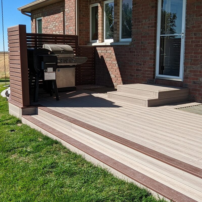 Extend your multi-level outdoor living with this massive backyard transformation by DeckPro LLC, pictured here in a transition from winter to spring. We took a multi-story house with uncompleted areas and rough dirt work and created a luxurious, fully-functional sanctuary. The expansive new structure features multiple raised decks with integrated privacy screening and covered sections complete with recessed lighting, defining functional zones perfect for relaxation and large-scale entertaining. We installed high-quality, durable composite decking and paired it with safe and sophisticated dark vertical perimeter railings. The sturdy retreat includes a massive and inviting set of stairs leading to a concrete patio level and a beautifully integrated hot tub surround and under-deck enclosed storage, creating a truly unique tranquillity sanctuary perfect for any large property.