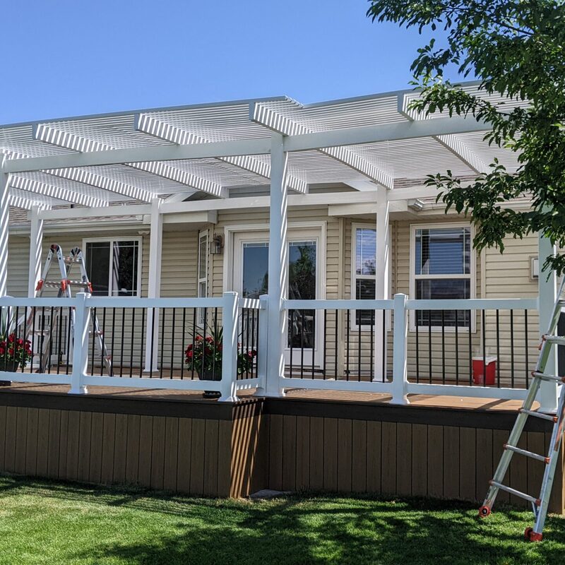 Expand your multi-level outdoor living with this dramatic backyard transformation by DeckPro LLC. This functional retreat seamlessly transitions from a construction phase with framing, raw dirt, and a raw pool to a massive and inviting sanctuary. The expansive new structure seamlessly connects a raised two-story home to a restored in-ground pool area and stamped concrete lower patios, defining functional zones perfect for swimming, sunbathing, dining, and relaxation. We installed high-performance composite decking and paired it with safe and sophisticated black vertical perimeter railings. Direct access via multiple existing glass doors, including sliding glass doors to defined covered patio sections with integrated recessed ceiling lighting, allows for effortless evening use. The 'After' shot reveals massive comprehensive staircases, a built-in hot tub surround, and hidden enclosed storage with custom doors. Pictured on a beautiful day with distinct shadows, this sturdy retreat borders a large grassy yard bordered by trees.