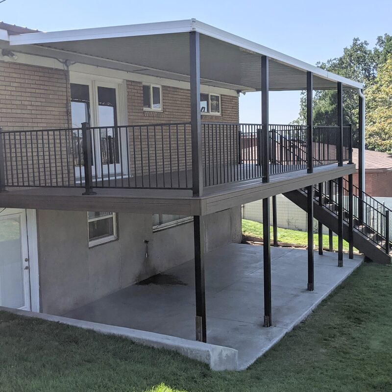 This recent project by DeckPro LLC showcases a durable second-story composite deck featuring sleek black metal railing. The design not only provides a beautiful upper-level outdoor space but also creates a functional, shaded concrete patio area underneath.