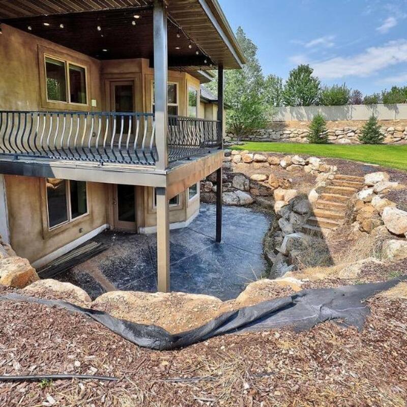 Maximize your home's potential with a custom multi-level outdoor living space from DeckPro LLC. This project features a spacious upper-level deck with a unique curved railing, perfectly complementing the home's architecture. Below, a walk-out basement opens onto an expansive concrete patio, creating two distinct areas for relaxing and entertaining.