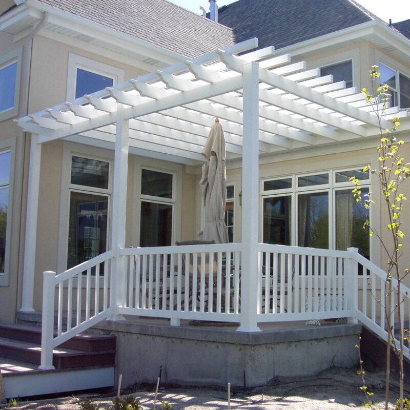 Transform your luxury home's outdoor experience with a substantial, custom-designed, attached vinyl pergola and railing system from [Your DeckPro LLC Branch Name]. This stunning project seamlessly integrates a grand, lattice-top pergola with durable support columns, providing perfect patio shade against the client's beige-stucco residence. The main platform is a low-maintenance concrete slab, which we’ve enhanced by adding wide, dark-brown wood-grain composite decking stairs on both the left and right for elegant access.
