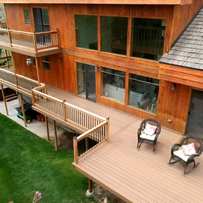 Transform your backyard into a sprawling outdoor retreat. This expansive, multi-level custom deck features low-maintenance composite decking and sleek black metal railings, providing the ultimate space for relaxation and entertaining in the Snake River Valley.