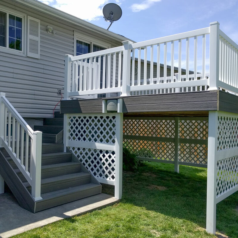 Achieve a clean, finished look for your backyard with a custom DeckPro LLC project. This raised grey composite deck features durable white vinyl railing and matching lattice skirting to beautifully enclose the under-deck area for a polished appearance.