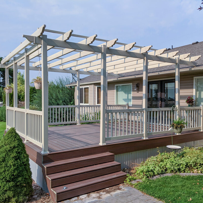 We are thrilled to showcase this exquisite outdoor transformation by DeckPro LLC. This raised composite deck project features a large, freestanding vinyl pergola that defines and shades the main seating area. The deck itself is constructed from premium composite decking boards with a rich wood-grain texture and contrasting deep brown field color, framed by clean light-tan vinyl railings.