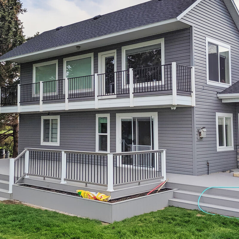 Transform your home's exterior with a complete multi-level outdoor living solution from DeckPro LLC. This project features a private second-story balcony and an expansive lower deck with custom built-in planters, all built with durable grey composite decking and modern railing.