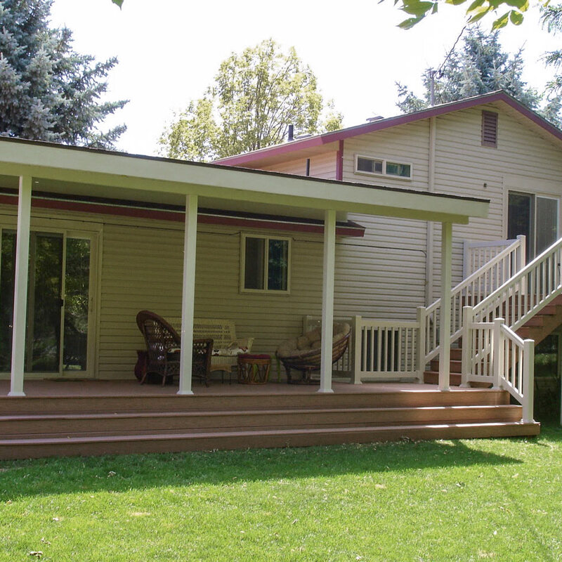 Create your dream outdoor oasis with a custom multi-level deck from DeckPro LLC. This expansive project features durable brown composite decking and a large, solid white patio cover, providing a perfect shaded retreat for relaxation and entertaining, rain or shine. The design includes an upper-level balcony and wide steps leading down to the main patio area, all finished with clean white vinyl railing.