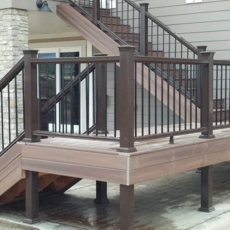 Elevate your multi-level home with a low-maintenance solution. This professional installation features durable composite decking on a lower landing, paired with sturdy metal railings. The design connects the ground floor to upper levels through matching composite stairs, all accented by classic white post caps. The combination of materials ensures longevity against the elements while creating a modern, safe transition for your outdoor spaces. This type of multi-deck solution is perfect for increasing accessibility and functional square footage on a sloped or multi-story property.
